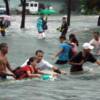 Residents cross a flooded street with the use of a rope in Quezon City.