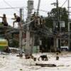 Residents clamber on electric wires to stay out of floodwaters while others wade neck-deep in Cainta Rizal, east of Manila.